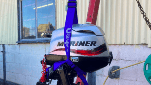 Outboard motor held in blue outboard motor sling from Barton Marine