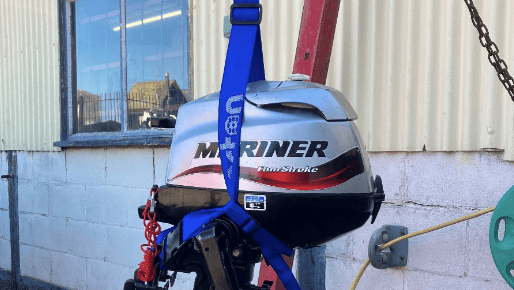 Outboard motor held in blue outboard motor sling from Barton Marine