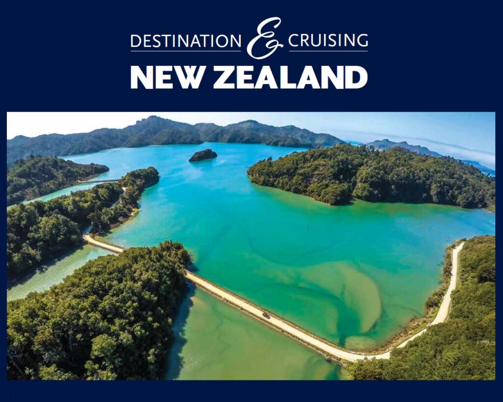 front cover of guide to New Zealand showing green blue water and tree-clad hills.