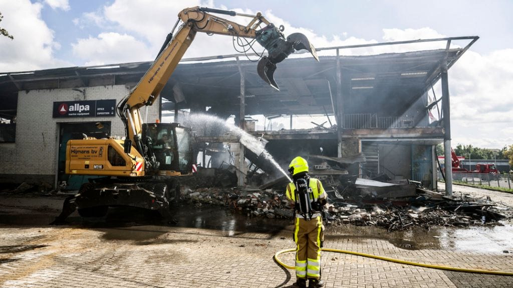 Firefighter sprays water on Allpa premises after it burnt to gorund