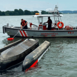 A flipped Sea-doo Switch being hauled by rescue boat