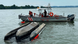 A flipped Sea-doo Switch being hauled by rescue boat