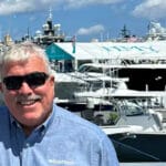 Man standing in front of boats looks at camera. It's Ian Atkins from Rightboat and he's smiling because Rightboat's market position is exactly where he wants it to be