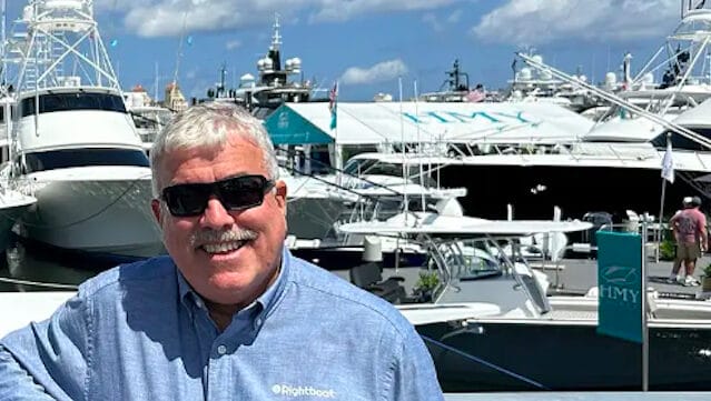 Man standing in front of boats looks at camera. It's Ian Atkins from Rightboat and he's smiling because Rightboat's market position is exactly where he wants it to be