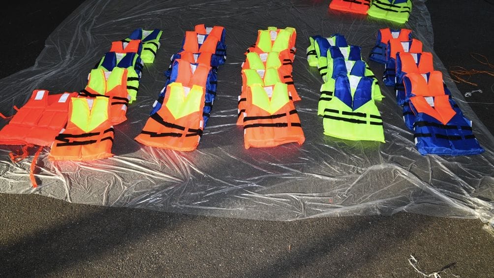 Multi-coloured lifejackets laid out in lines after being seized by NCA