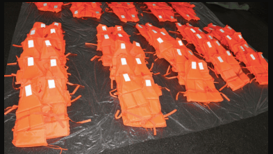 orange lifejackets laid out in lines after being seized by NCA