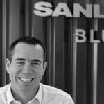 black and white photo businessman in white shirt with SanLorenzo sign behind