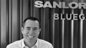 black and white photo businessman in white shirt with SanLorenzo sign behind