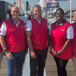 The team from Salt wear red gilets and stand on a pontoon