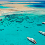 aerial view boats in crystal clear water with sand back. this is Saudi Arabia Red Sea