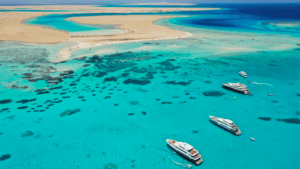 aerial view boats in crystal clear water with sand back. this is Saudi Arabia Red Sea