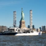 Energy Observer catamaran arriving in New York by Statue of Liberty