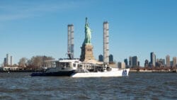 Energy Observer catamaran arriving in New York by Statue of Liberty