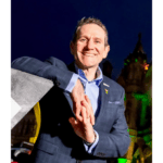 Andy Hindley smiles at camera in front of a night sky