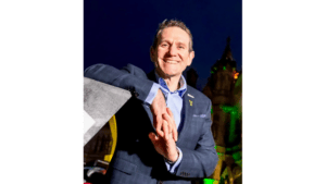 Andy Hindley smiles at camera in front of a night sky