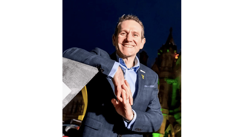 Andy Hindley smiles at camera in front of a night sky