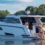 Family sat on boat stern on calm lake. This is Aquador model by Nimbus Group which has recently appointed new dealer in Norway