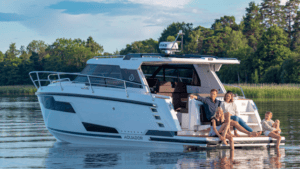 Family sat on boat stern on calm lake. This is Aquador model by Nimbus Group which has recently appointed new dealer in Norway