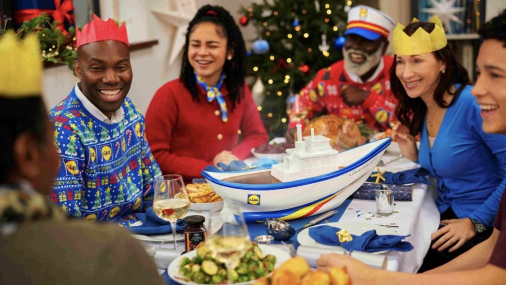 family sitting at christmas dinner table with large gravy boat