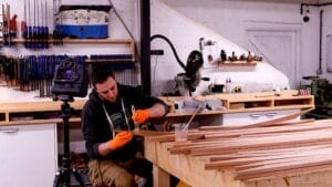 Dan Lee sits in workshop as he glues scarf joints