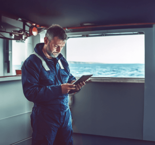 Seafarer looks at phone with waves in background generated by AI for marine use by KVH Industries