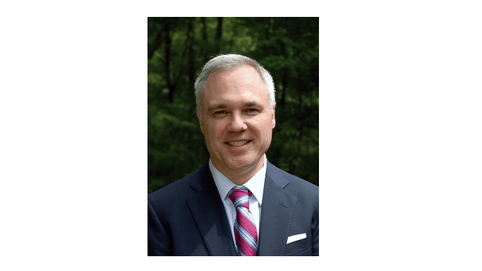 Man in suit smiles at camera. This is Klein Marine Systems' Ted Curley