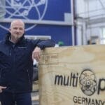 Marko Böhme standing in front of wooden multiplex logo