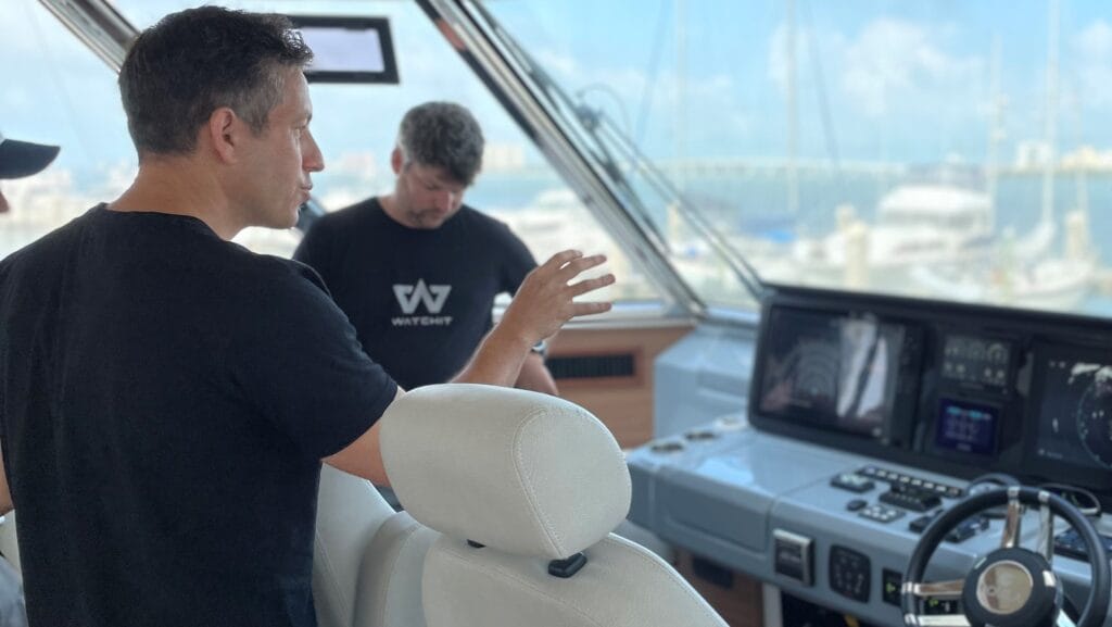 two men on a boat's bridge using navigation devices