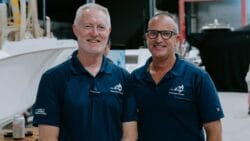 Two men in blue polo shirts in boat factory