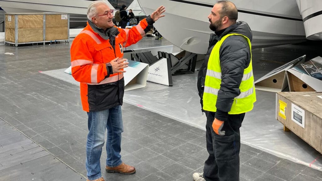 Petros Michelidakis in orange jacket chats to exhibitor as boot Dusseldorf takes shape for 2025