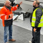 Petros Michelidakis in orange jacket chats to exhibitor as boot Dusseldorf takes shape for 2025