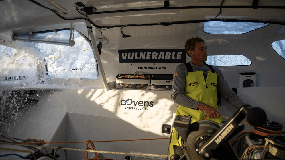 Thomas Ruyant  competes in Vendee Globe - seen standing in IMOCA as sea crashes through cabin