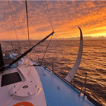 Vendée Globe boat with sunrise behind