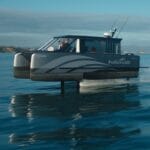 A small ferry on hydrofoil glides across smooth sea