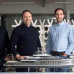 Vitruvius Yacht Design team poses with model yacht.